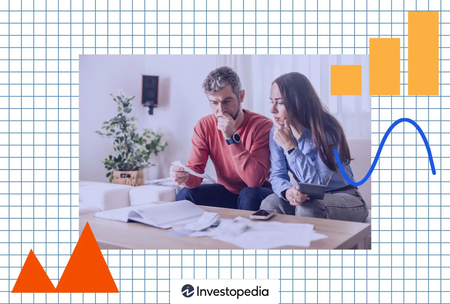 A couple sitting on a couch reviewing documents